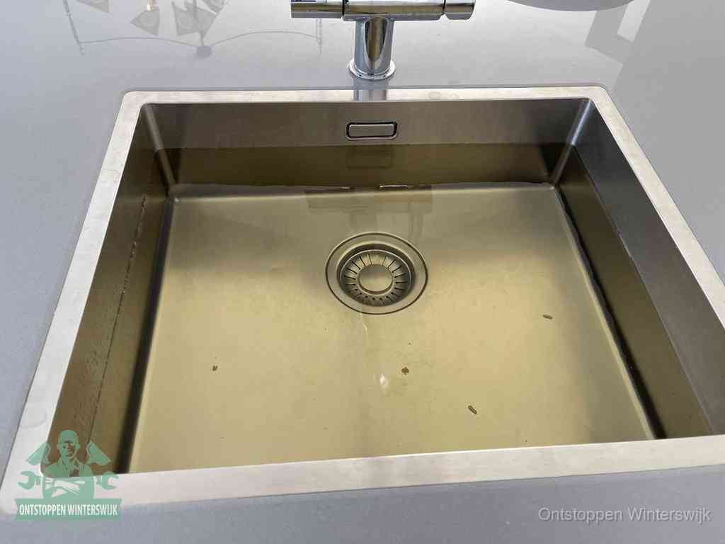 Een RVS spoelbak met stilstaand water dat niet wegloopt, een van de eerste signalen van een beginnende verstopping in Winterswijk