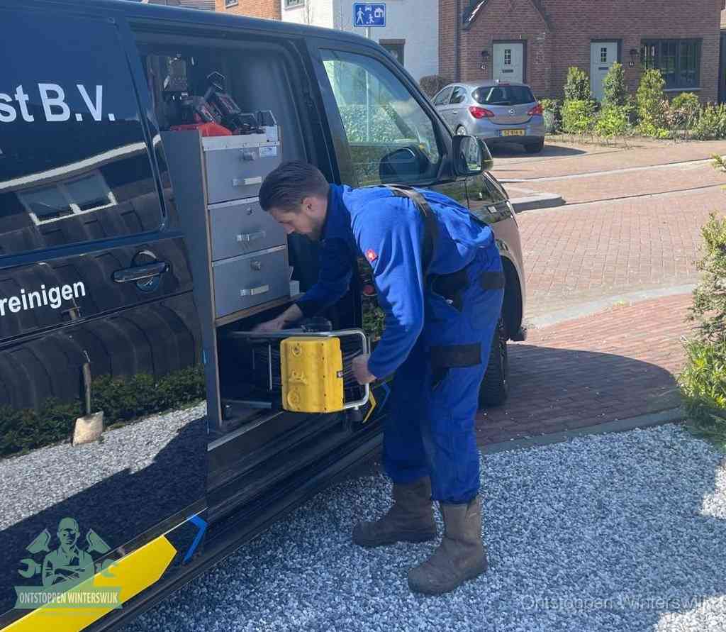 Een monteur pakt gereedschap uit de bedrijfsbus, het moment om een professionele ontstoppingsdienst in te schakelen in Winterswijk