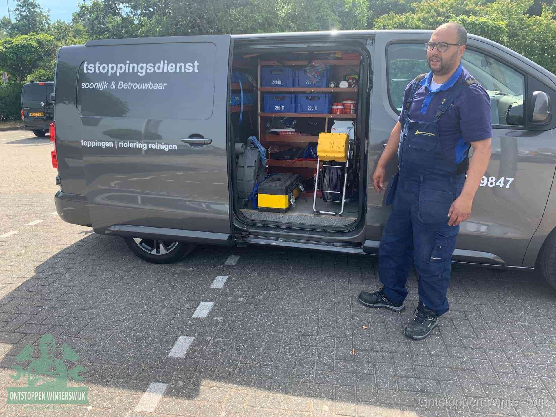 Een monteur staat klaar bij zijn bedrijfsbus met gereedschap, de vaste werkwijze van de ontstoppingsdienst in Winterswijk